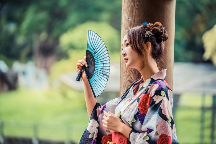 Asian woman in kimono holding a hand fan