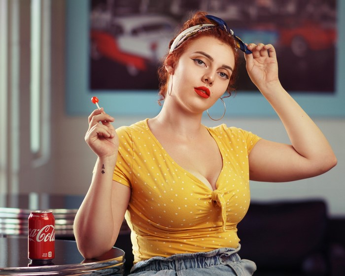 Redhead girl with lollipop and Coca-Cola