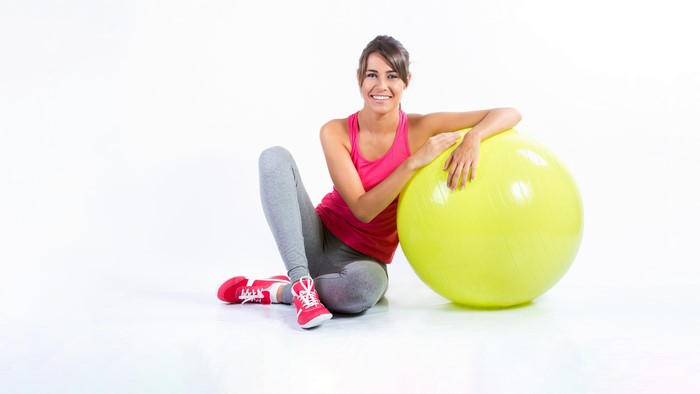 Woman sitting with a fitness ball