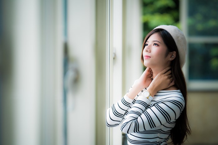 Asian woman with brown hair wearing a beret and striped shirt