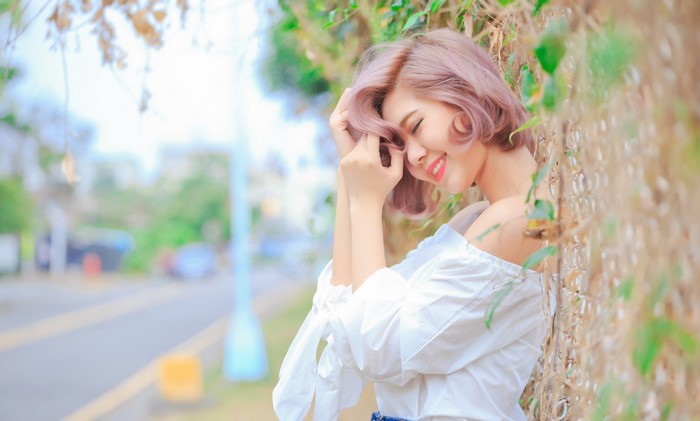 Asian woman with pink hair smiling