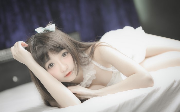Asian girl with bowknot lying down