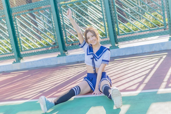 Asian girl in school uniform sitting on ground
