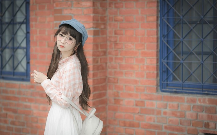 Asian girl with brown hair, glasses, and baseball cap