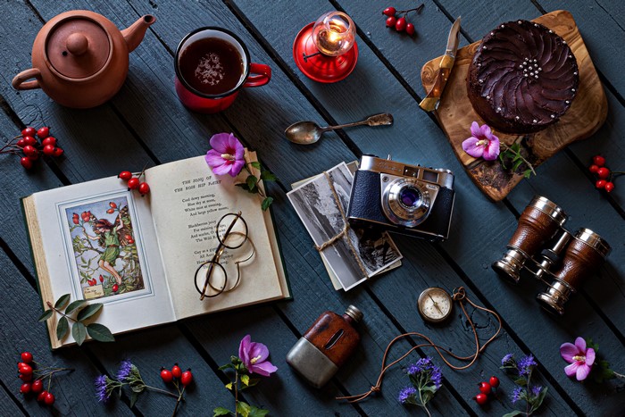 Still-life with cake, tea, camera, and book