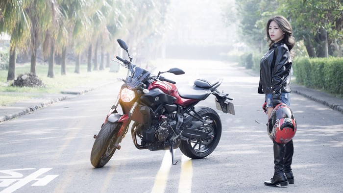 Asian woman with Yamaha motorcycle and helmet