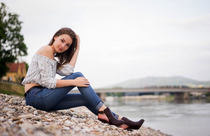 Maren sitting on a beach by the water