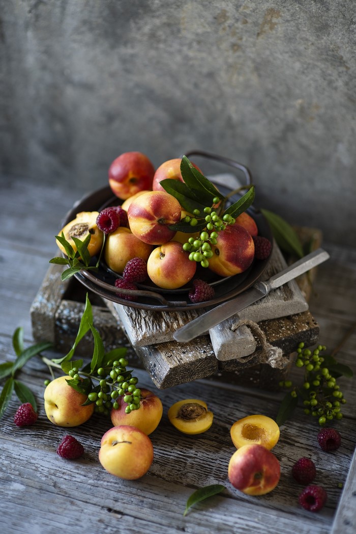 Apricots and raspberries on wooden planks