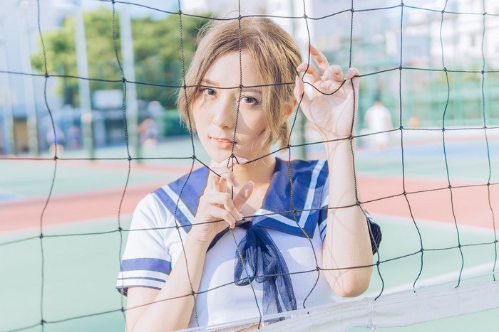 Asian schoolgirl behind a net