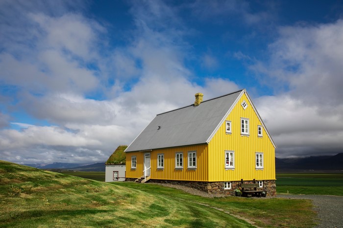 Yellow house in Iceland with clouds