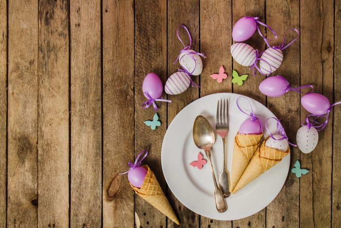 Easter eggs in ice cream cones on a plate with cutlery