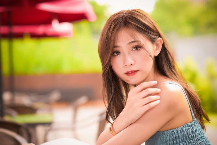 Asian woman with brown hair, hands, bokeh