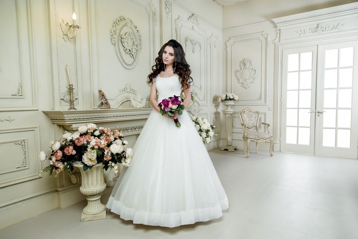 Bride in White Dress Holding Bouquet