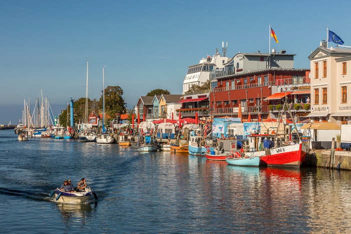 Boats docked at a German waterfront with houses and yachts