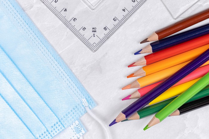 Face mask and colored pencils with ruler