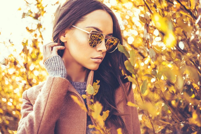 Woman with sunglasses in autumn foliage