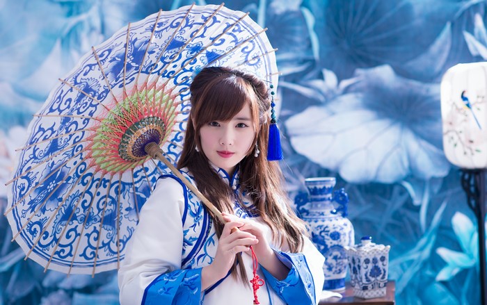 Asian woman in traditional dress holding an umbrella