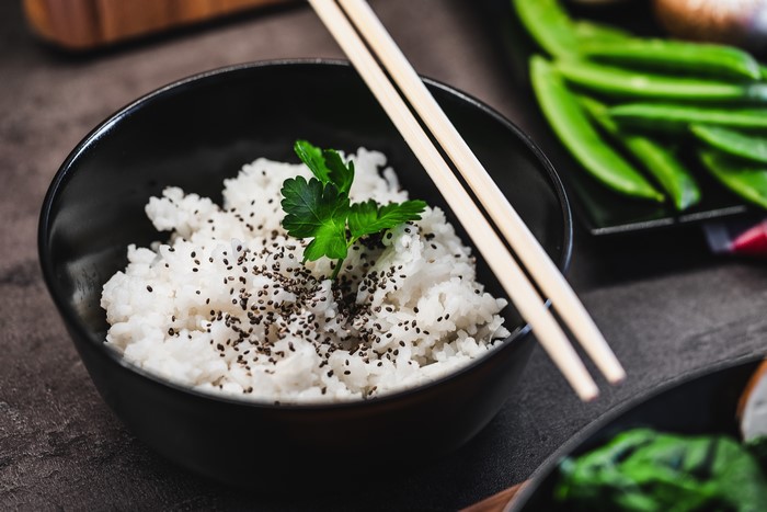 Rice in a bowl with chopsticks and garnish