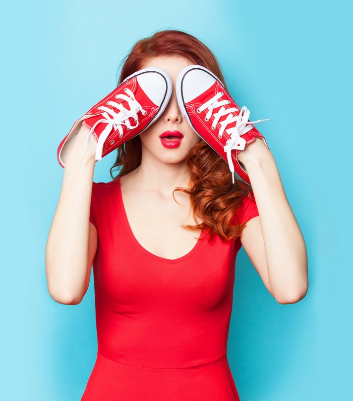Redhead girl with red shoes covering eyes