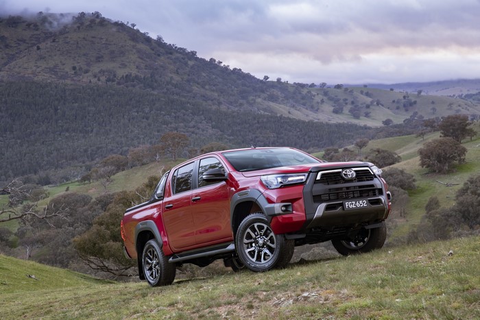 Red Toyota Hilux Rogue Double Cab pickup truck on a grassy hill