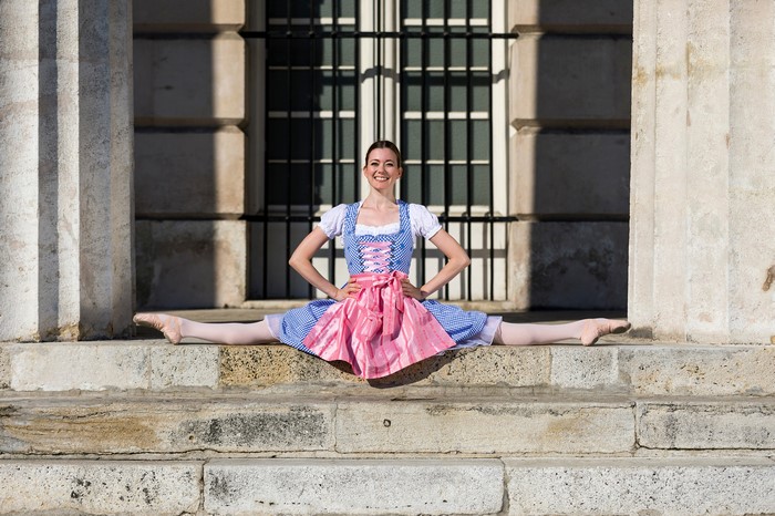 Ballet dancer in dirndl on stairs