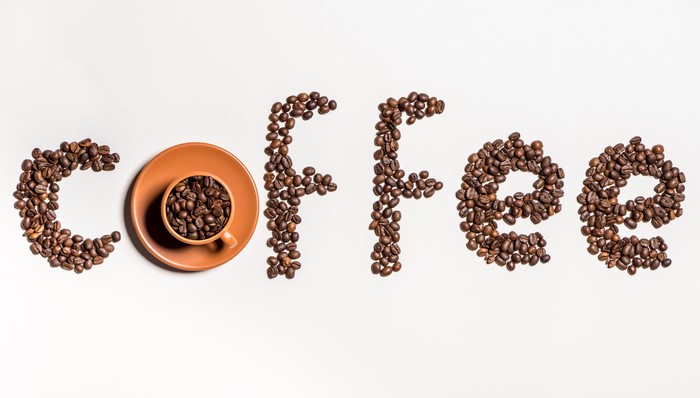 Coffee beans arranged to spell "Coffee" with a cup