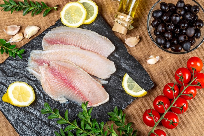 Raw Fish Fillets with Tomatoes, Olives, Lemons, and Garlic