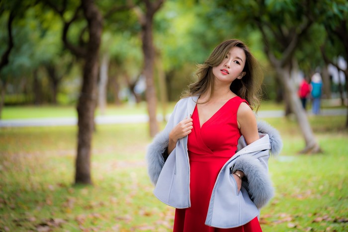 Asian woman in red dress with grey coat