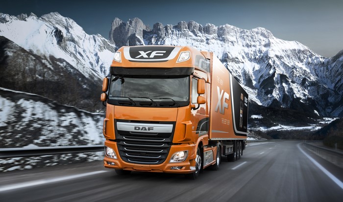 Orange DAF XF Truck Driving on Mountain Road