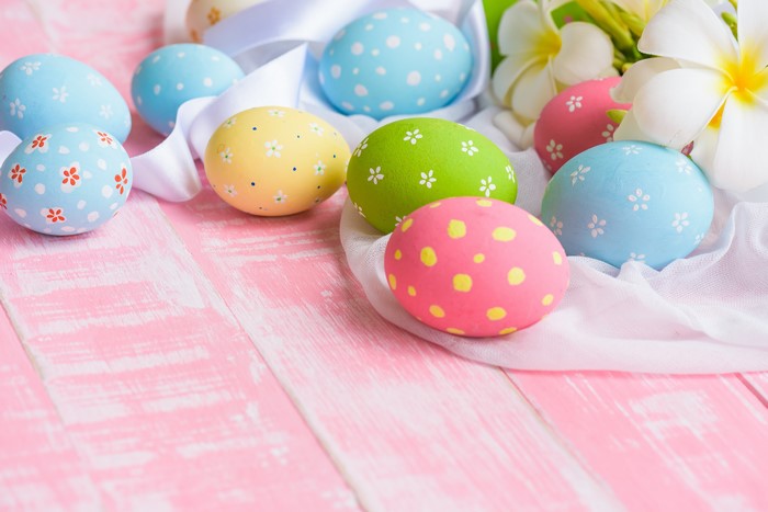 Easter Eggs on Pink Wooden Surface with Flowers