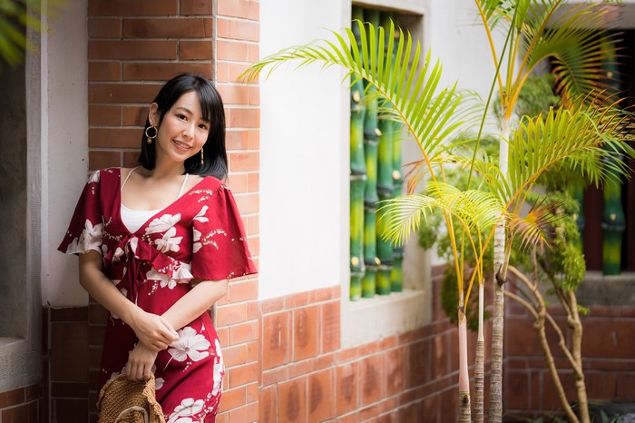 Asian woman in red floral dress smiling