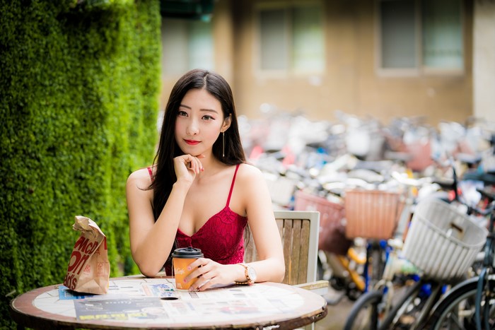 Asian woman with coffee and McDonald's bag at table