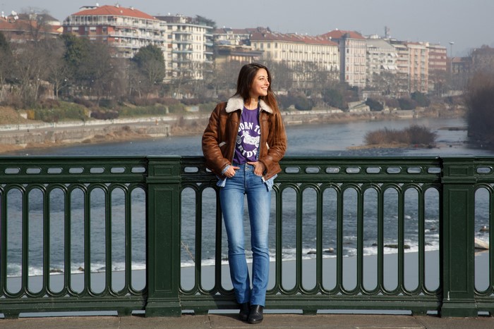 Lorena Garcia Smiling on Bridge in Jacket and Jeans