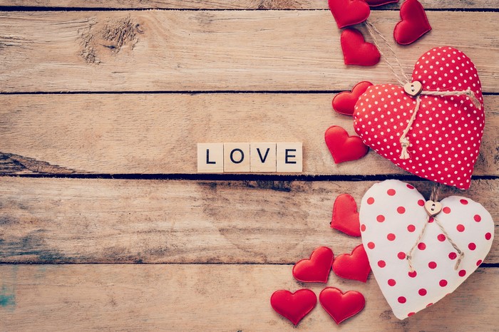 Love spelled out with wooden blocks and hearts on wood planks