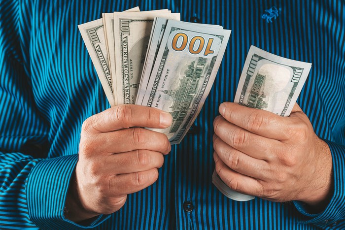 Man holding 100 dollar bills