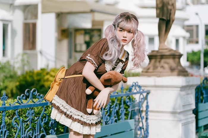 Asian girl in brown dress with teddy bear