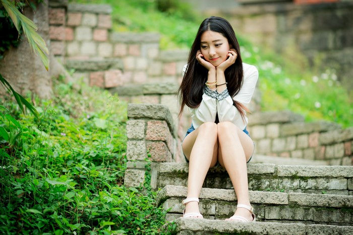 Brunette girl sitting on stone stairs