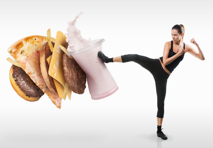 Woman kicking a pile of fast food and milkshake