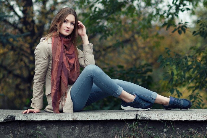 Woman in Jeans and Cloak Sitting Outdoors