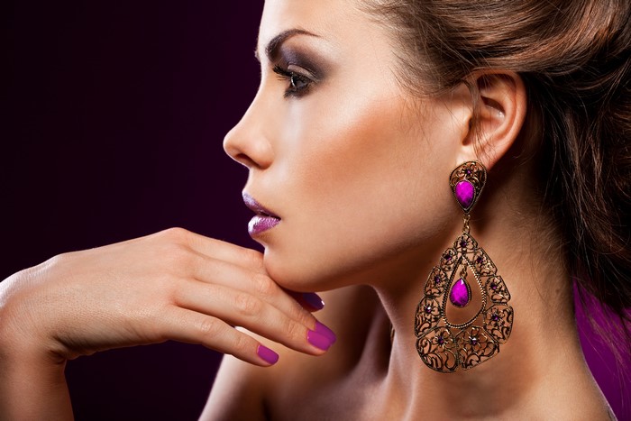 Woman with purple earrings and manicure