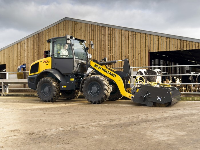 New Holland W70C HS tractor with a brush attachment