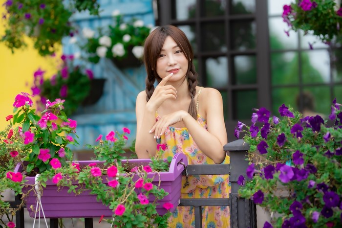 Asian woman with braid hair posing among flowers