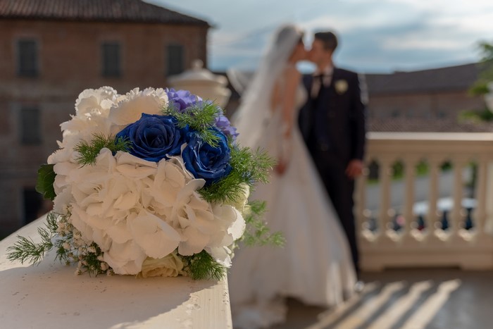 Wedding bouquet with bride and groom kissing