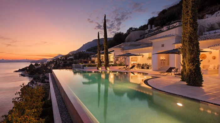 Villa with infinity pool overlooking the sea at sunset in Corfu, Greece