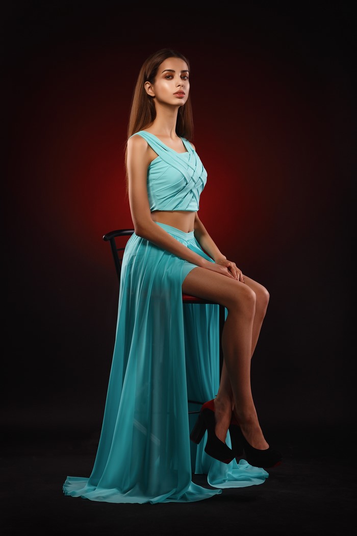 Liza in Elegant Aqua Dress Sitting on Chair