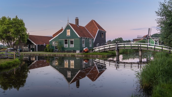 Houses and windmill in Zaandam, Netherlands with canal reflection