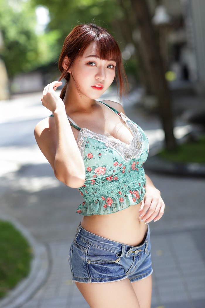 Asian Woman Posing in Floral Blouse and Denim Shorts