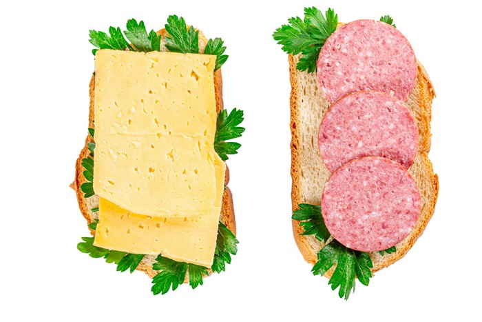 Two open-faced sandwiches with cheese and sausage