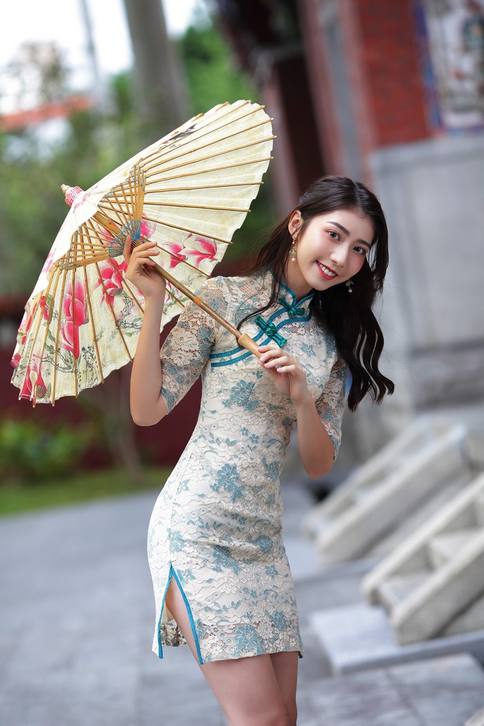 Woman in Cheongsam holding a floral umbrella