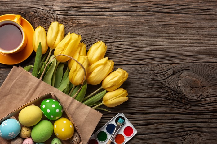 Easter Tulips and Painted Eggs on Wooden Table